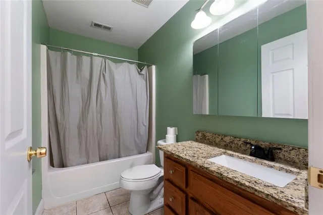 a bathroom with a granite countertop sink toilet and mirror