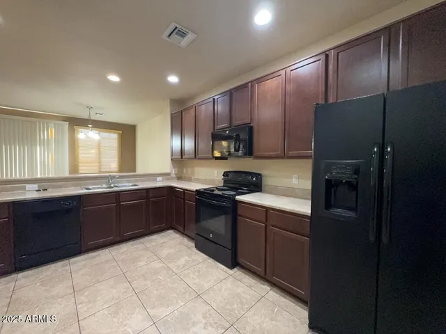 a kitchen with stainless steel appliances granite countertop wooden cabinets a stove top oven a sink and dishwasher
