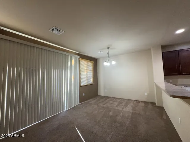 a view of an empty room with a kitchen