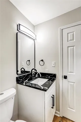 a bathroom with a granite countertop sink and a mirror
