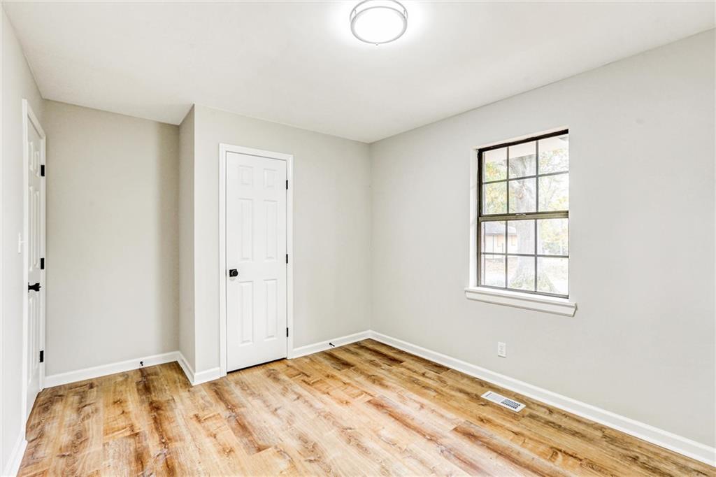 122 Capitol Avenue Winder, GA 30680 - Photo 22 of 34 a view of an empty room with wooden floor and a window