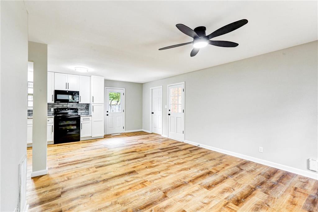 122 Capitol Avenue Winder, GA 30680 - Photo 5 of 34 a view of empty room with wooden floor and ceiling fan