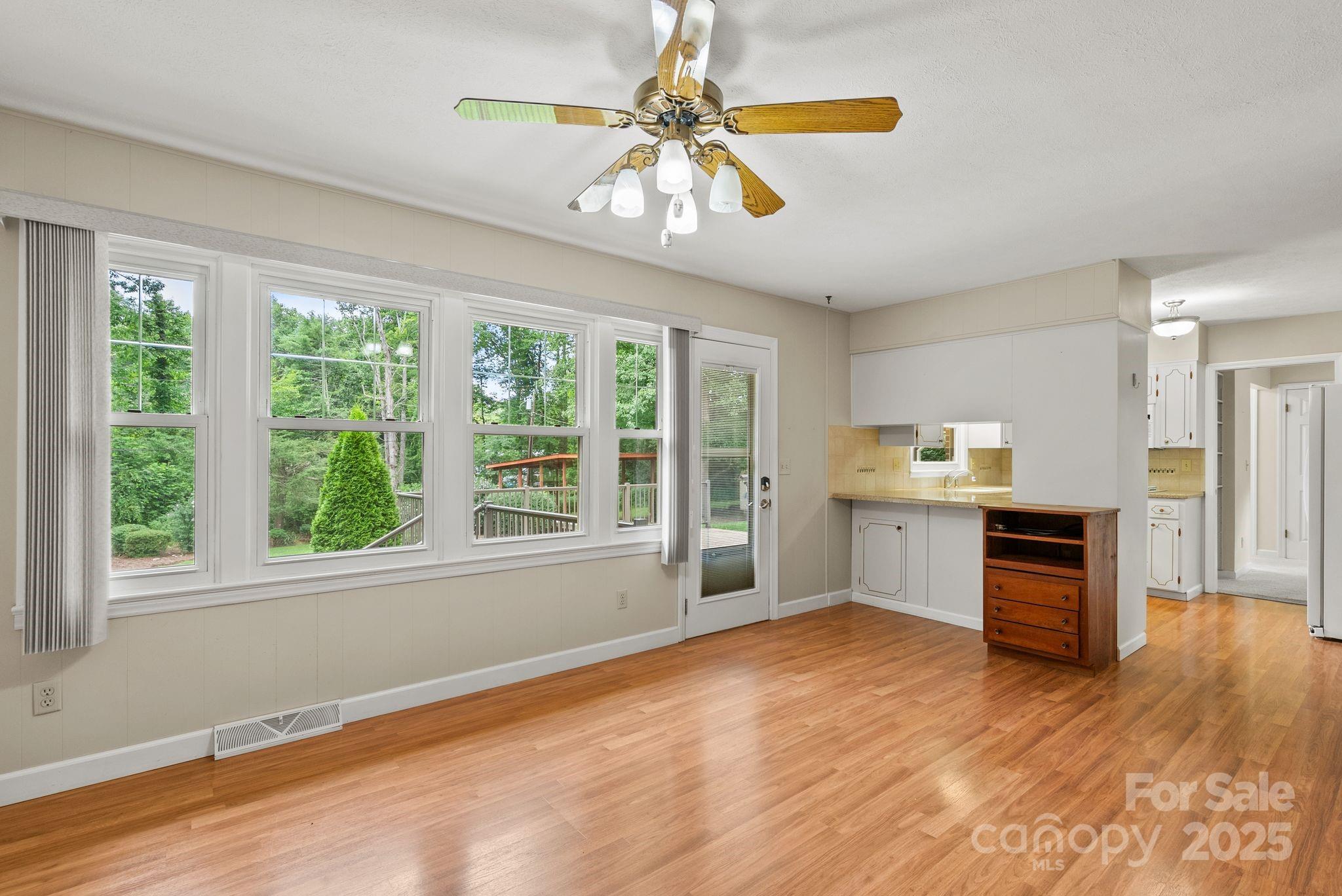 6693 Brevard Road Etowah, NC 28729 - Photo 18 of 42 a kitchen with kitchen island a sink wooden floor and a large window