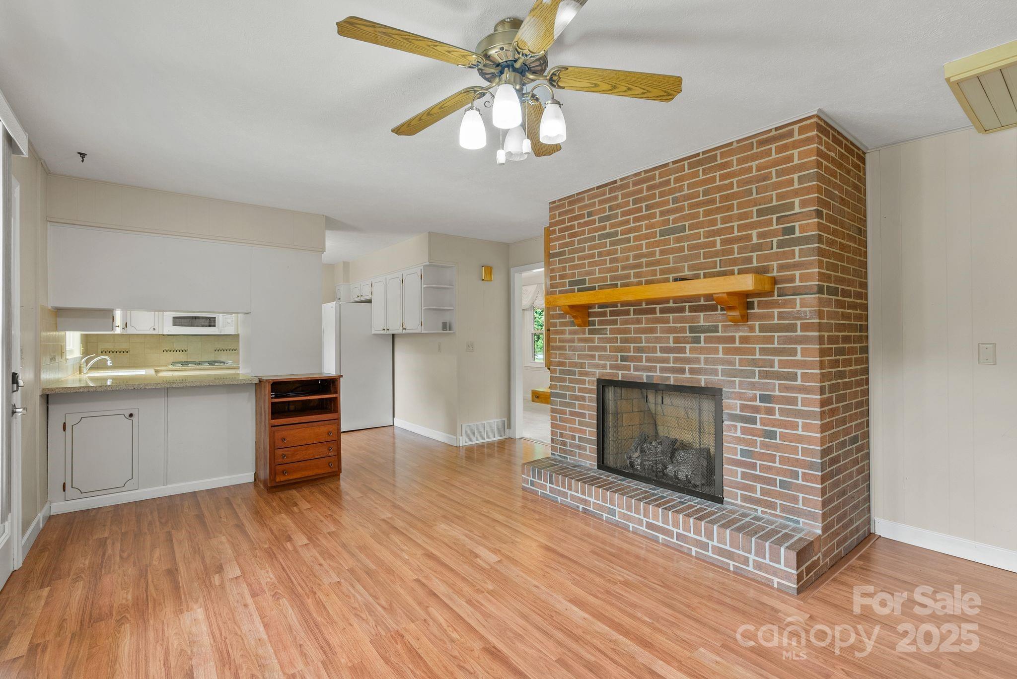 6693 Brevard Road Etowah, NC 28729 - Photo 19 of 42 a kitchen with stainless steel appliances kitchen island wooden cabinets and fireplace