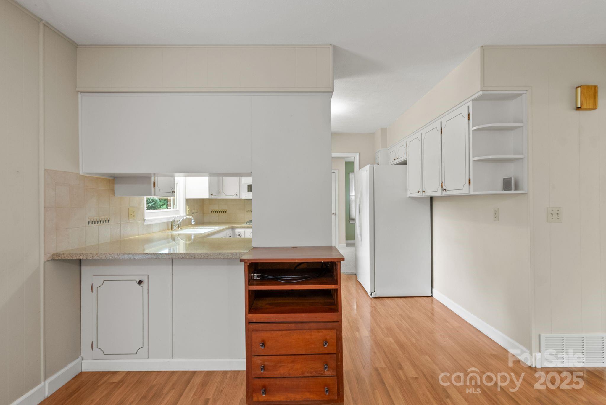 6693 Brevard Road Etowah, NC 28729 - Photo 20 of 42 a kitchen with granite countertop white cabinets and stainless steel appliances