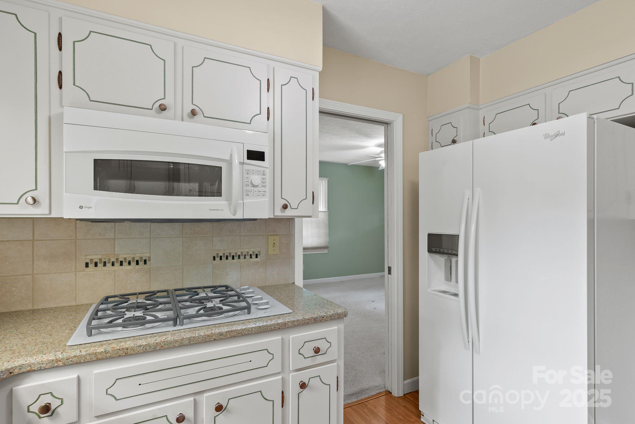 6693 Brevard Road Etowah, NC 28729 - Photo 23 of 42 a kitchen with stainless steel appliances granite countertop white cabinets and white stove