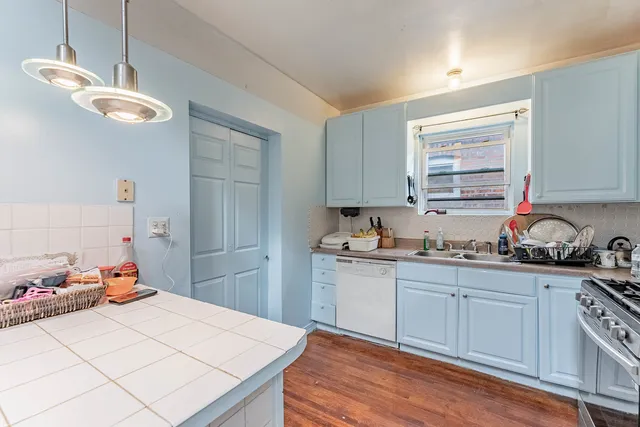 a kitchen with a sink cabinets and wooden floor