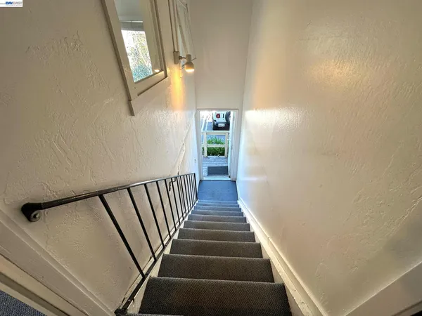 a view of staircase with railing and a window