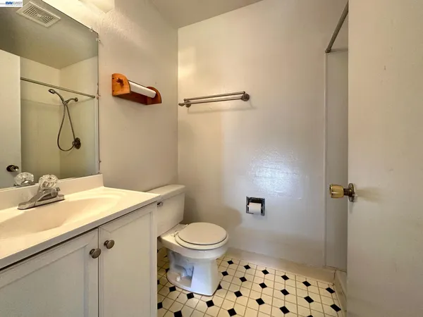 a bathroom with a granite countertop sink a toilet and shower