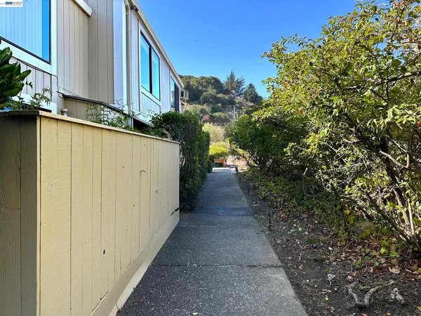 a view of a pathway of a house with wooden fence