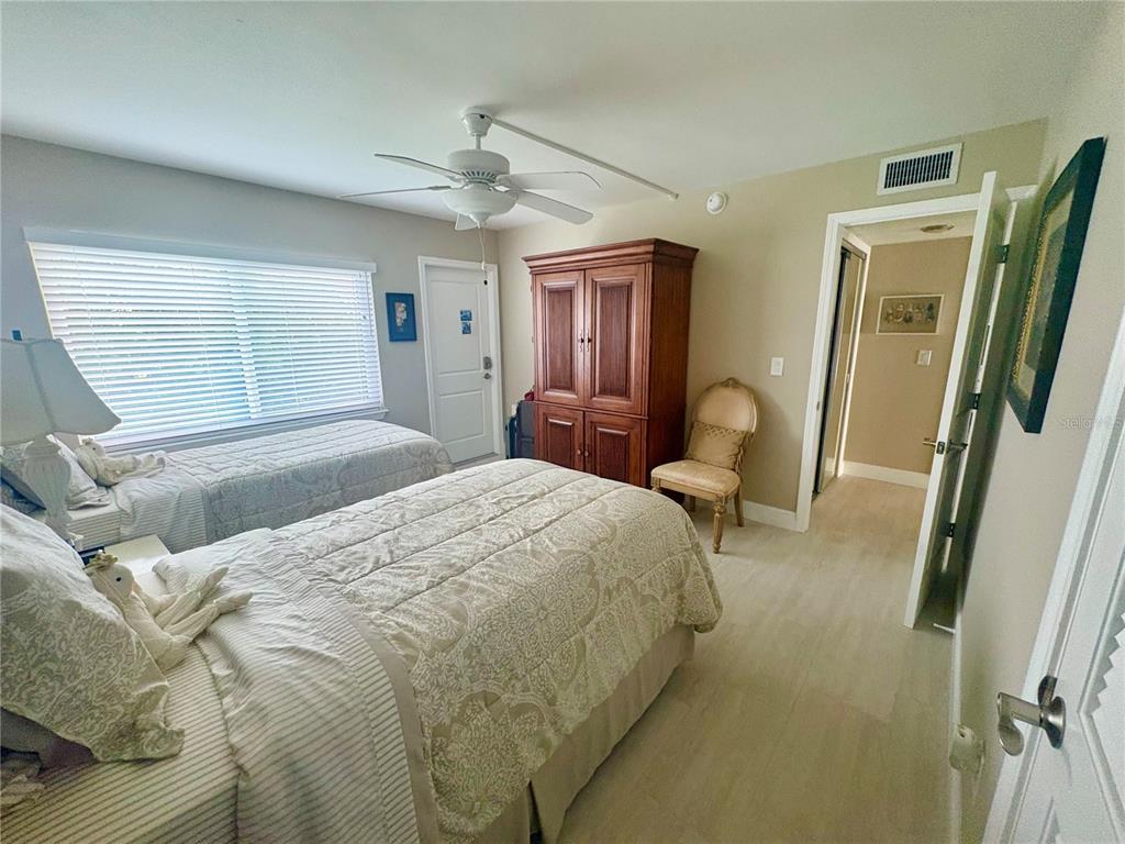 4455 Duhme Road, Unit 103 St. Petersburg, FL 33708 - Photo 22 of 37 a bedroom with a bed large mirror and wooden floor