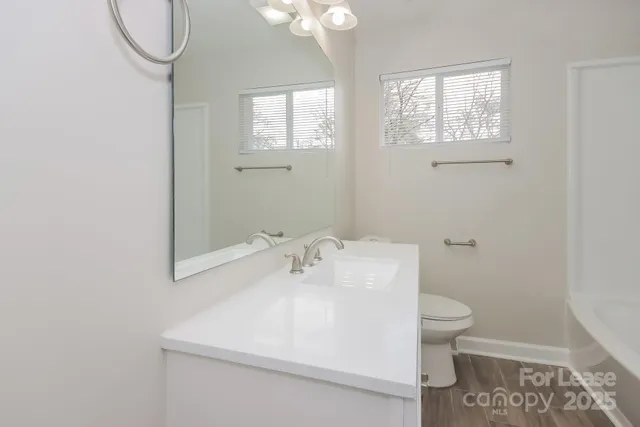 a bathroom with a sink a toilet and a mirror