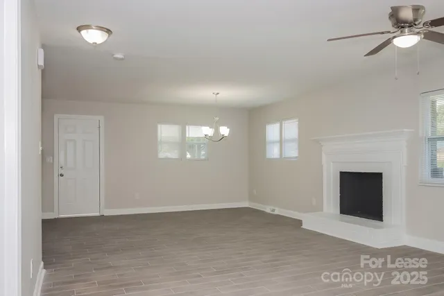 a view of an empty room with a fireplace and a window