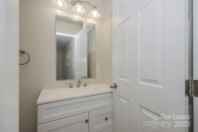 a bathroom with a sink a light fixture and a mirror