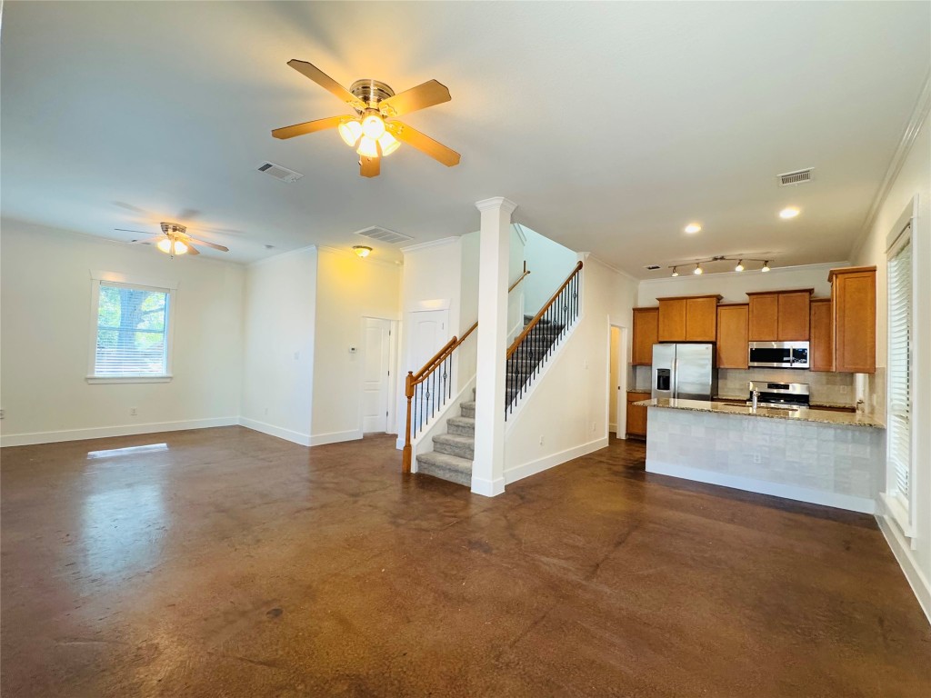 609 Franklin Boulevard, Unit A Austin, TX 78751 - Photo 19 of 19 Kitchen featuring maple cabinets, open floor plan, a peninsula, concrete flooring, and appliances with stainless steel finishes