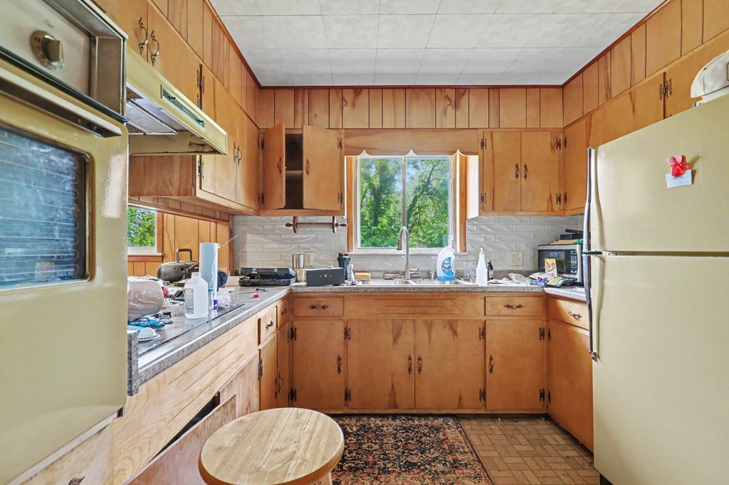 63 Fort Butler Street Murphy, NC 28906 - Photo 10 of 30 a kitchen with a sink a refrigerator a window and cabinets