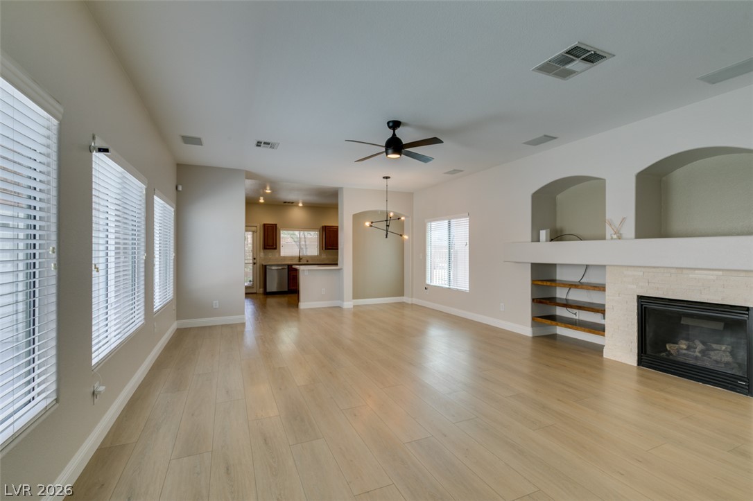 8909 Houston Ridge Avenue Las Vegas, NV 89178 - Photo 24 of 45 Natural light illuminates this spacious living area with fireplace and light wood flooring.