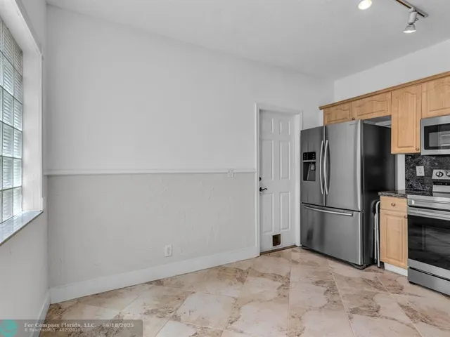a view of a kitchen with a refrigerator a microwave and a sink