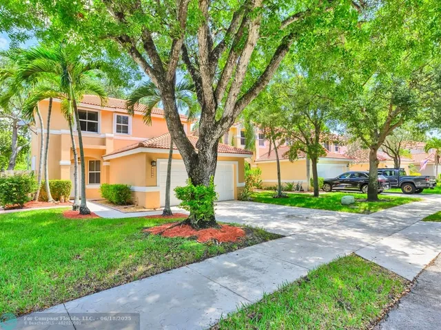 a front view of a house with a yard and a garden