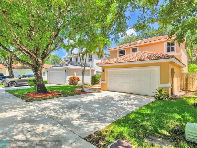 a front view of a house with a yard and a garden