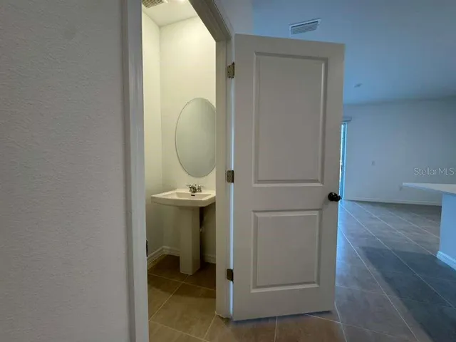 a bathroom with a granite countertop sink toilet mirror and bathtub