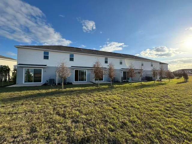 a view of backyard with seating space and wooden fence