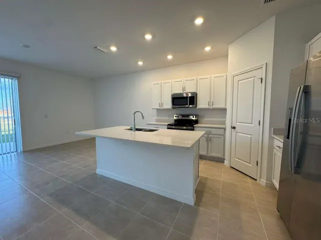 a kitchen with kitchen island a sink stainless steel appliances and cabinets