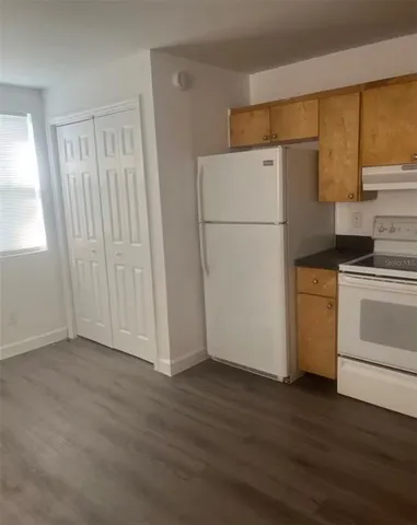 a view of a room with wooden floor and electronic appliances