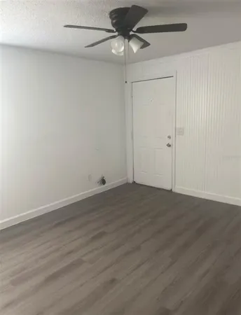 a view of a room with wooden floor and a ceiling fan