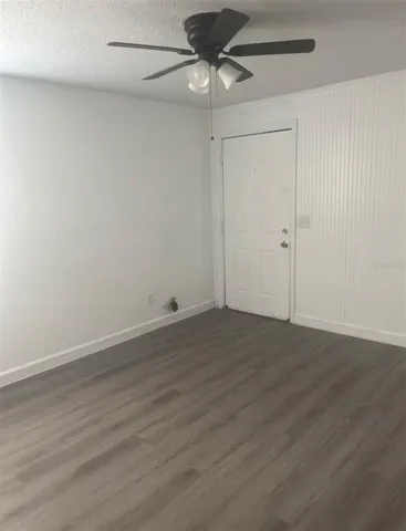 a view of a room with wooden floor and a ceiling fan