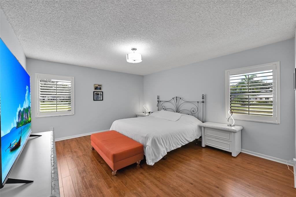 10788 Waterberry Drive Boca Raton, FL 33498 - Photo 13 of 30 a bedroom with a bed window and wooden floor