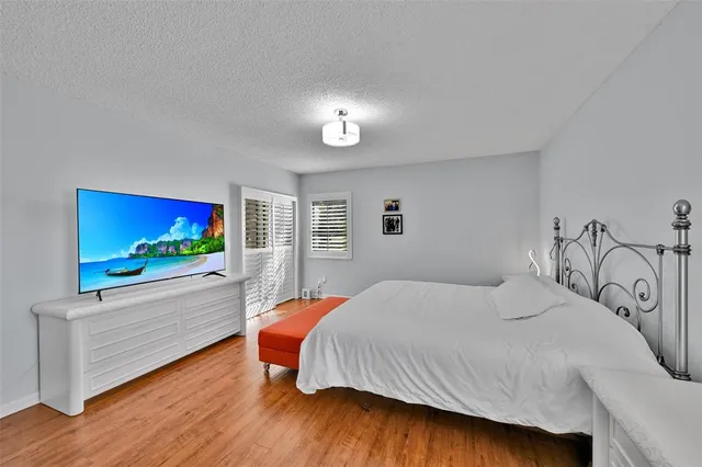 a bedroom with a bed and a flat screen tv