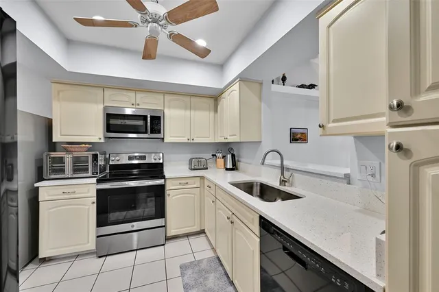 a kitchen with stainless steel appliances granite countertop a sink a stove top oven a refrigerator with island and cabinets