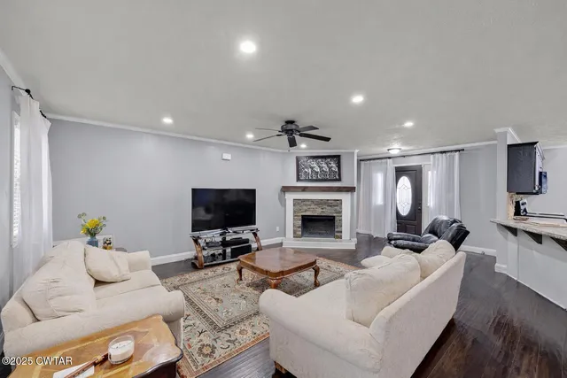 a living room with furniture a fireplace and a flat screen tv
