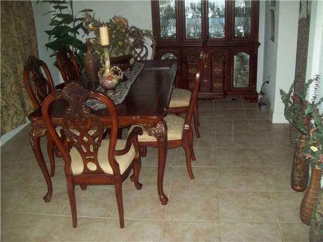 613 Southwest Homeland Road Port St. Lucie, FL 34953 - Photo 3 of 4 a view of a dining room with furniture and chandelier
