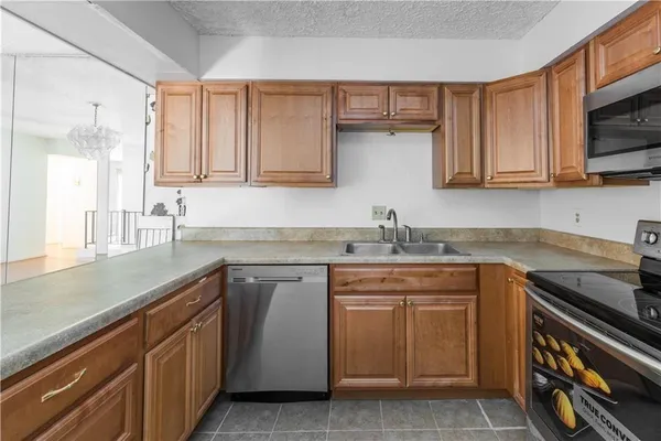 a kitchen with stainless steel appliances granite countertop a sink stove and microwave