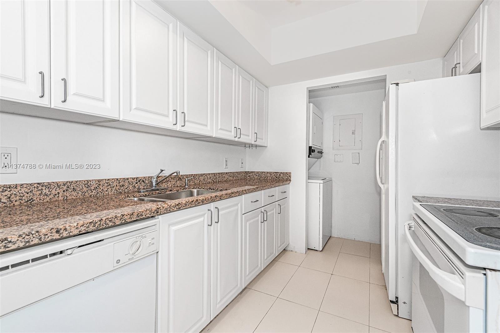 90 Alton Road, Unit 905 Miami Beach, FL 33139 - Photo 11 of 33 a kitchen with granite countertop white cabinets and stainless steel appliances