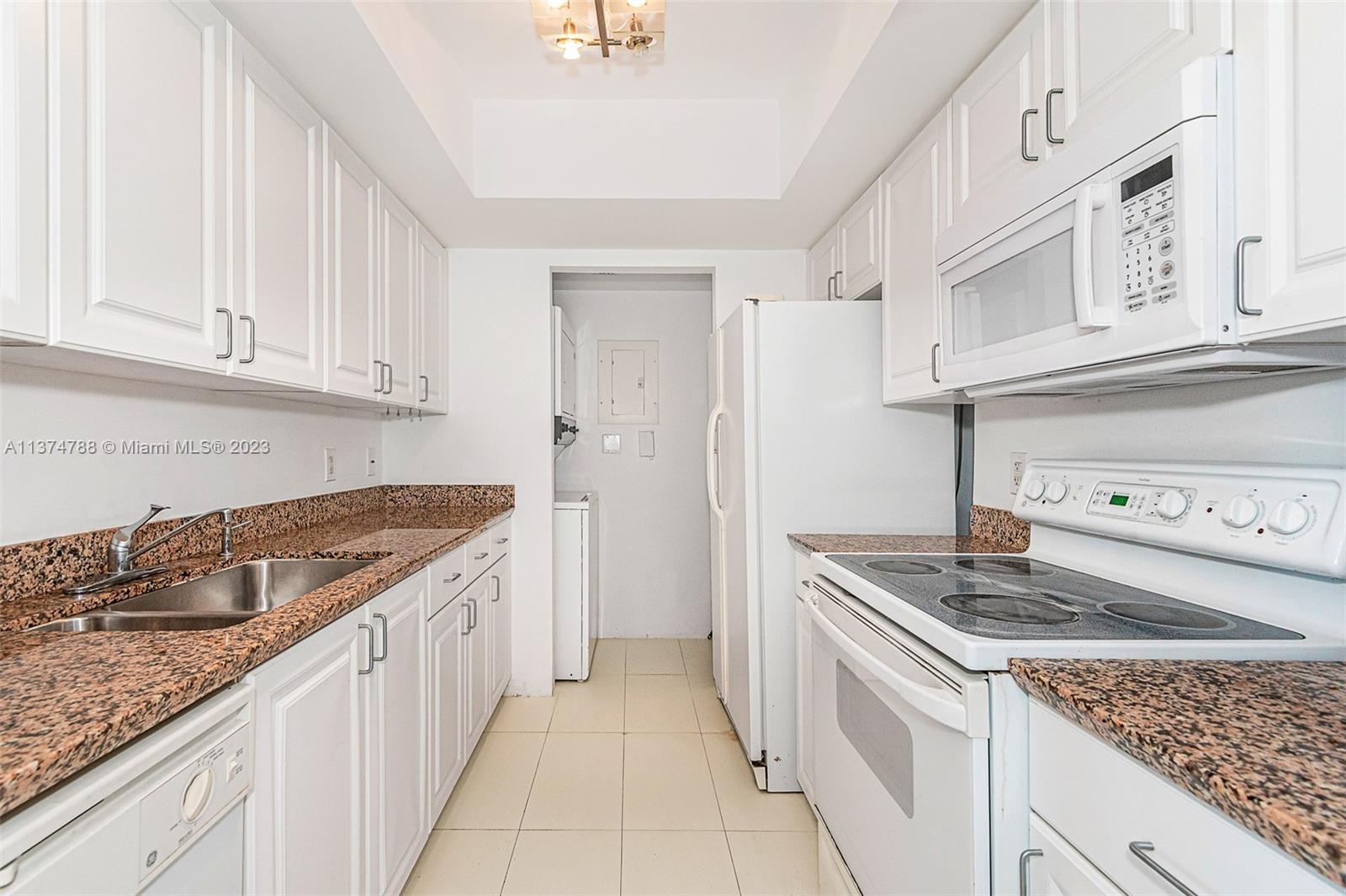 90 Alton Road, Unit 905 Miami Beach, FL 33139 - Photo 13 of 33 a kitchen with granite countertop a sink stove and cabinets