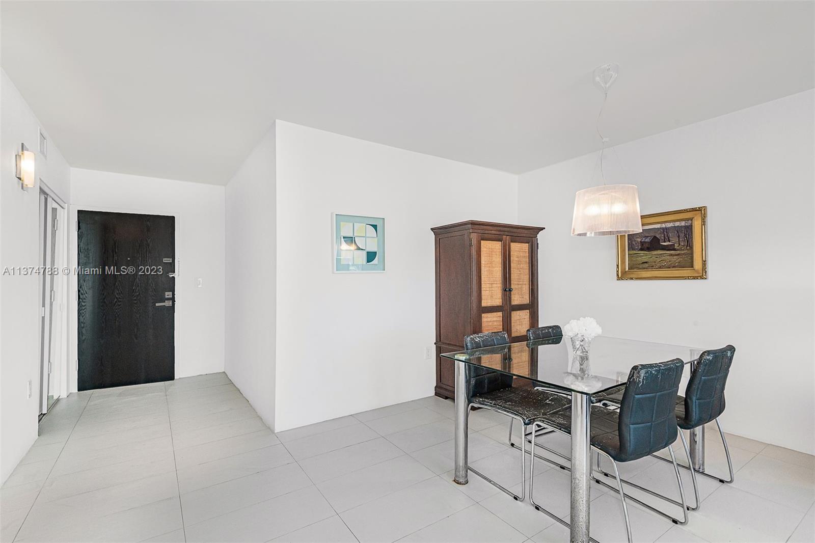 90 Alton Road, Unit 905 Miami Beach, FL 33139 - Photo 14 of 33 a workspace room with a table and chairs
