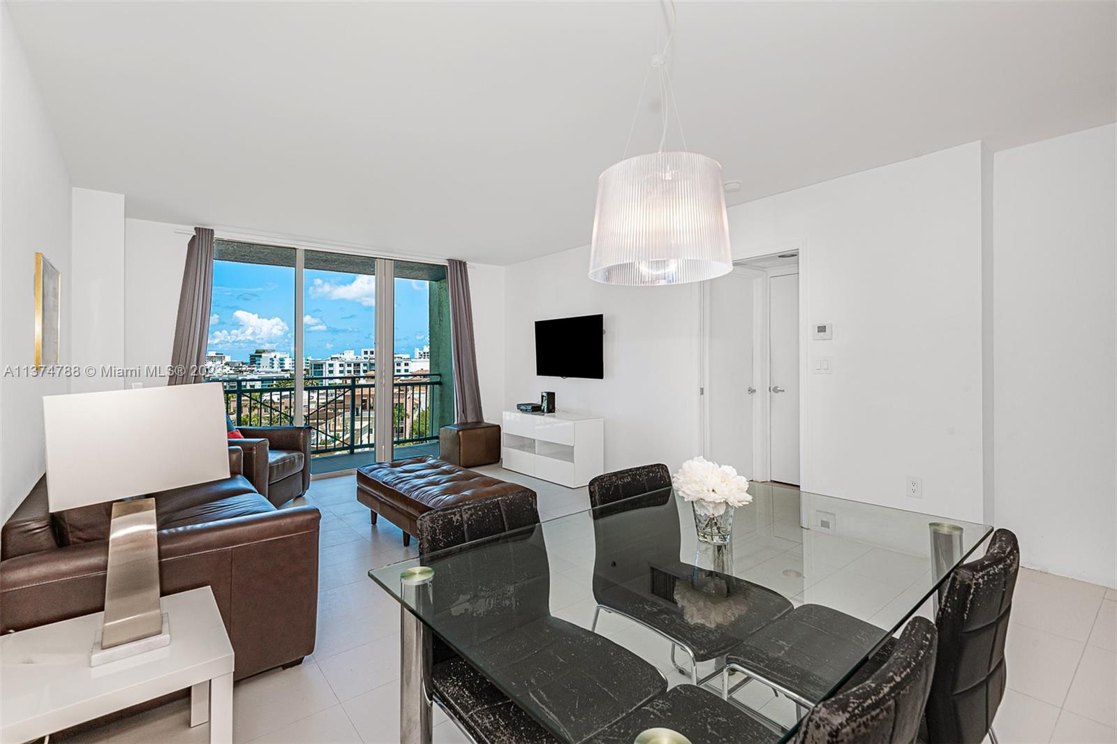 90 Alton Road, Unit 905 Miami Beach, FL 33139 - Photo 2 of 33 a living room with furniture a flat screen tv and a large window