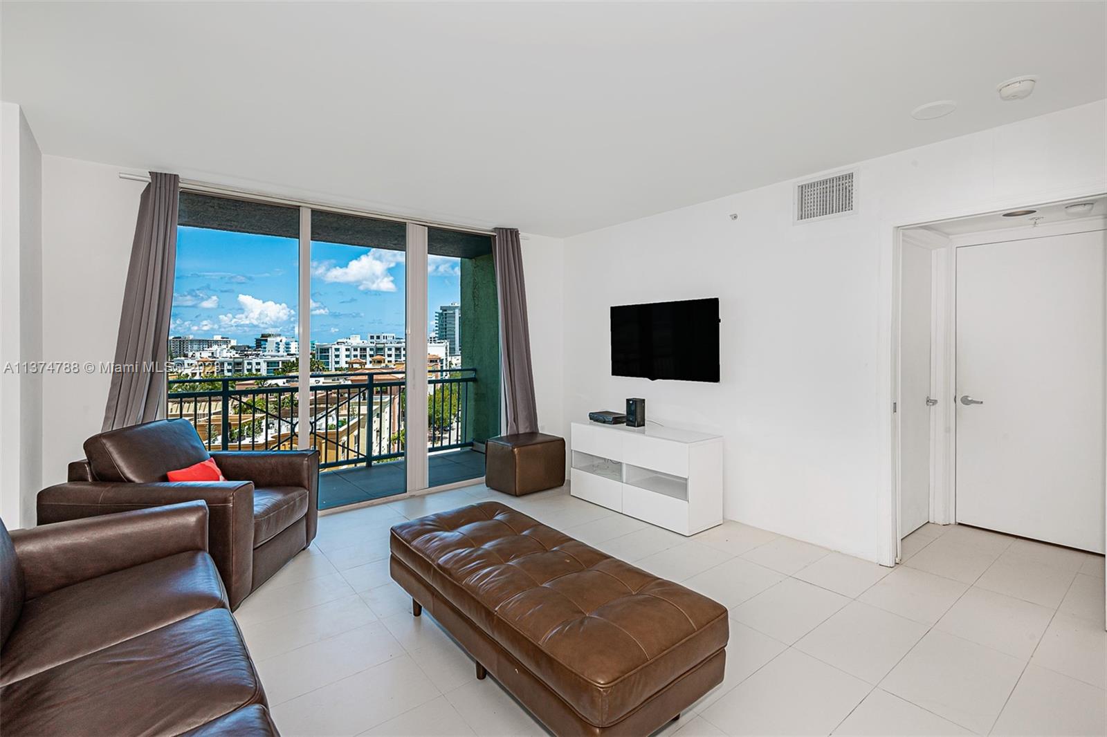 90 Alton Road, Unit 905 Miami Beach, FL 33139 - Photo 5 of 33 a living room with furniture window and a flat screen tv