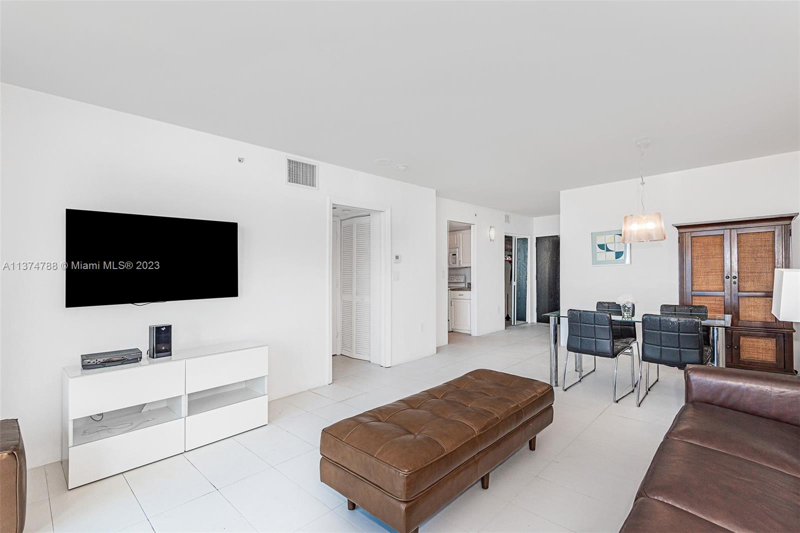 90 Alton Road, Unit 905 Miami Beach, FL 33139 - Photo 7 of 33 a living room with furniture and a flat screen tv