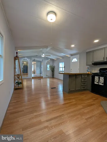 a view of a kitchen with kitchen island a sink dishwasher stove with wooden floor