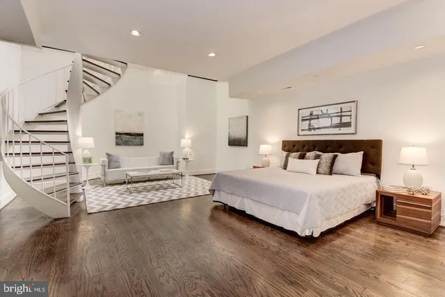 a spacious bedroom with a bed and a view of living room