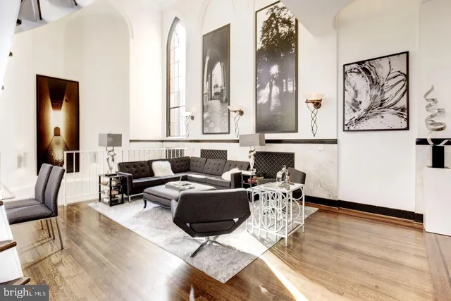 a living room with furniture a wooden floor and painting on the wall