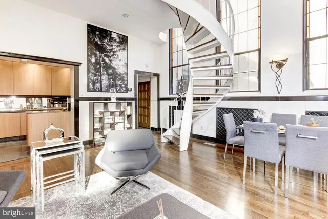 a living room with furniture a flat screen tv and a floor to ceiling window
