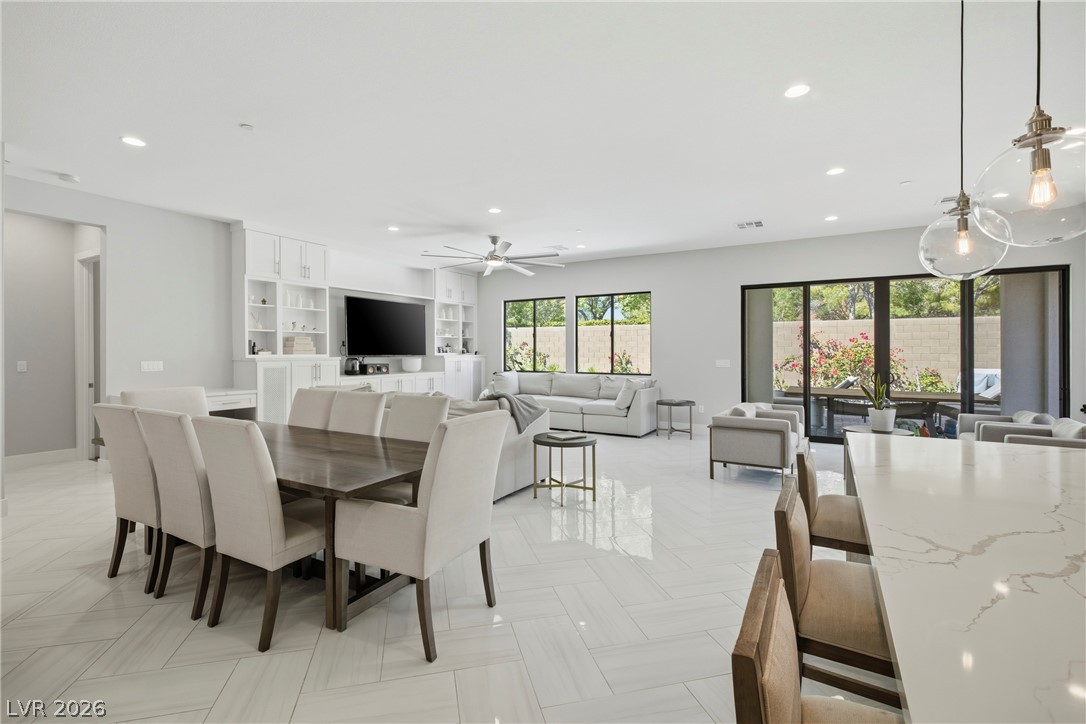 45 Garibaldi Way Henderson, NV 89011 - Photo 6 of 74 An open-concept living area flows seamlessly into the dining space, illuminated by abundant natural light and recessed lighting.