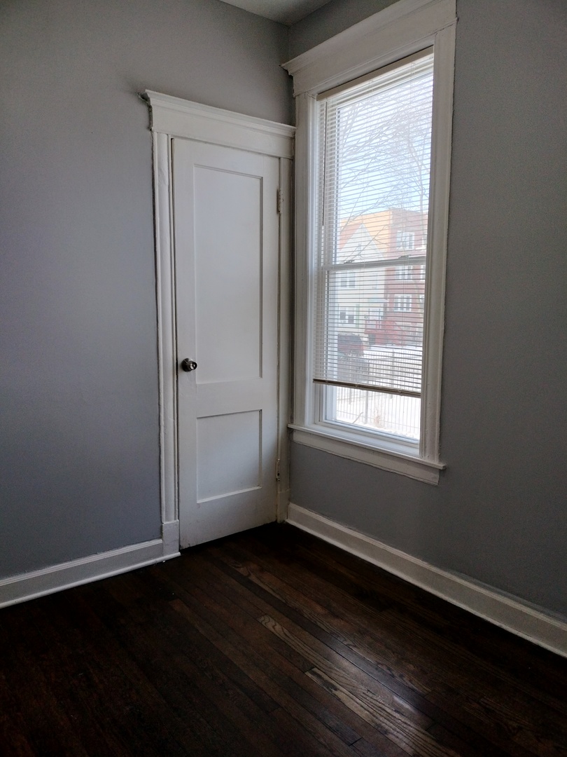 6719 South Sangamon Street, Unit 1 Chicago, IL 60621 - Photo 11 of 23 a view of an empty room with wooden floor and a window