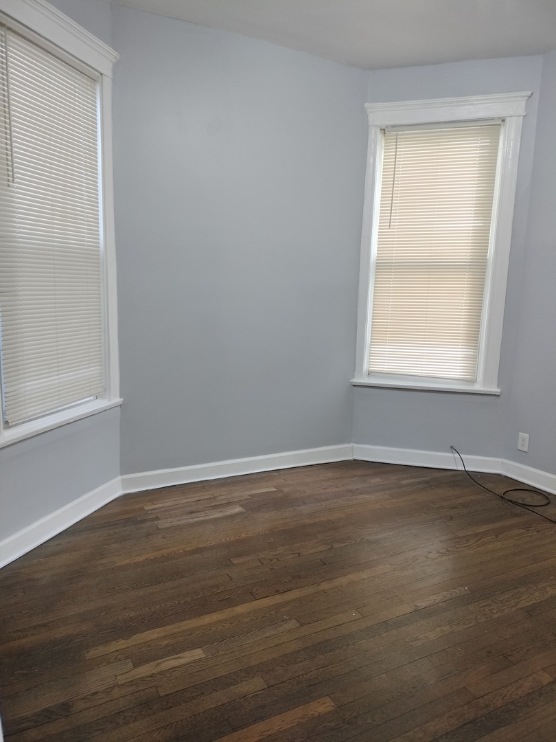 6719 South Sangamon Street, Unit 1 Chicago, IL 60621 - Photo 12 of 23 a view of an empty room with wooden floor and a window