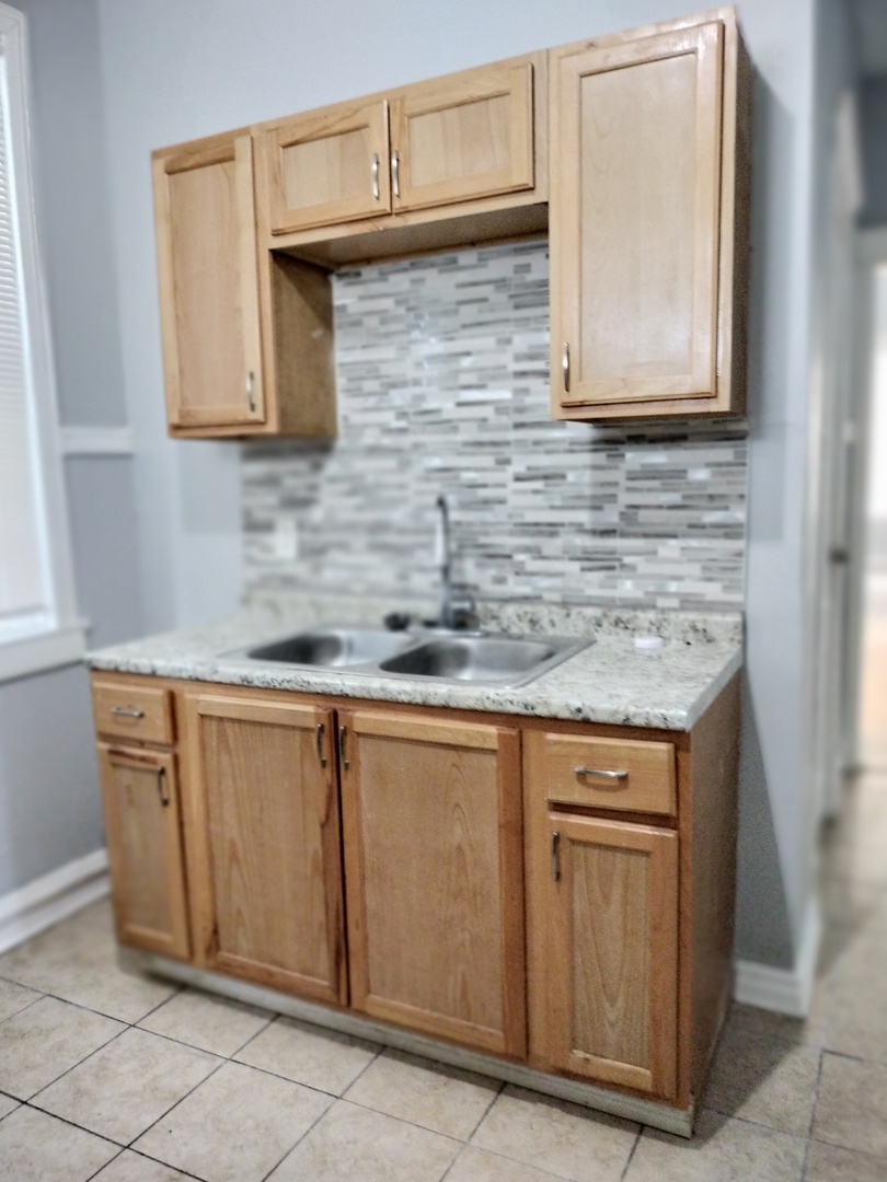 6719 South Sangamon Street, Unit 1 Chicago, IL 60621 - Photo 16 of 23 a kitchen with stainless steel appliances granite countertop a sink and cabinets